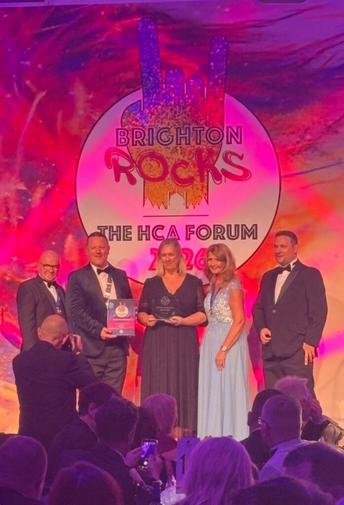 Erica Bell receiving her HCA trophy on stage