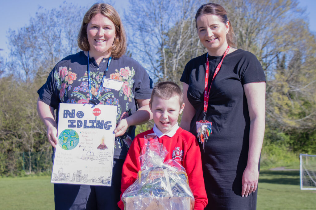 Two adults and a child with an environmental poster