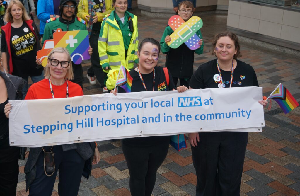 NHS staff on Pride parade with banner