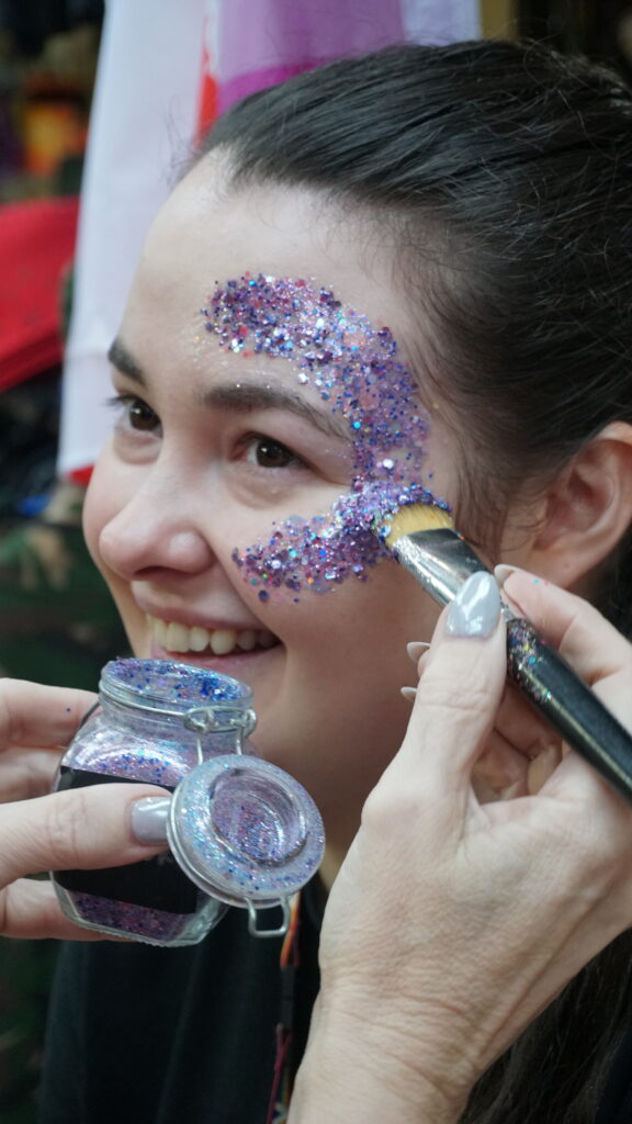 NHS staff member receiving glitter paint on face