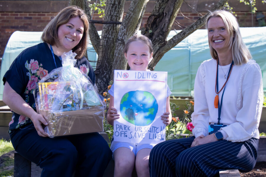 Two adults and a child with an environmental poster